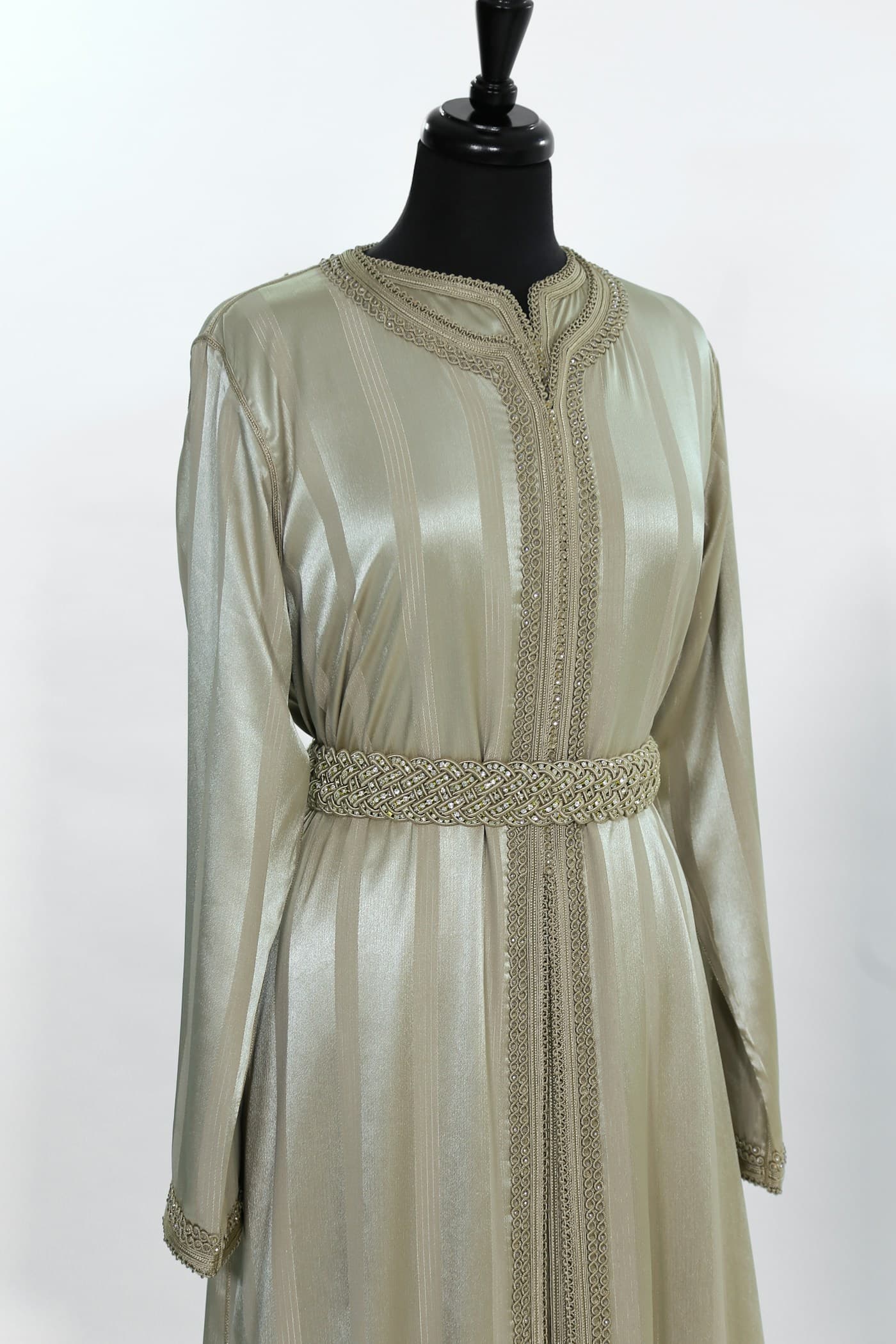 White long sleeve dress on a black hanger in an atelier setting.