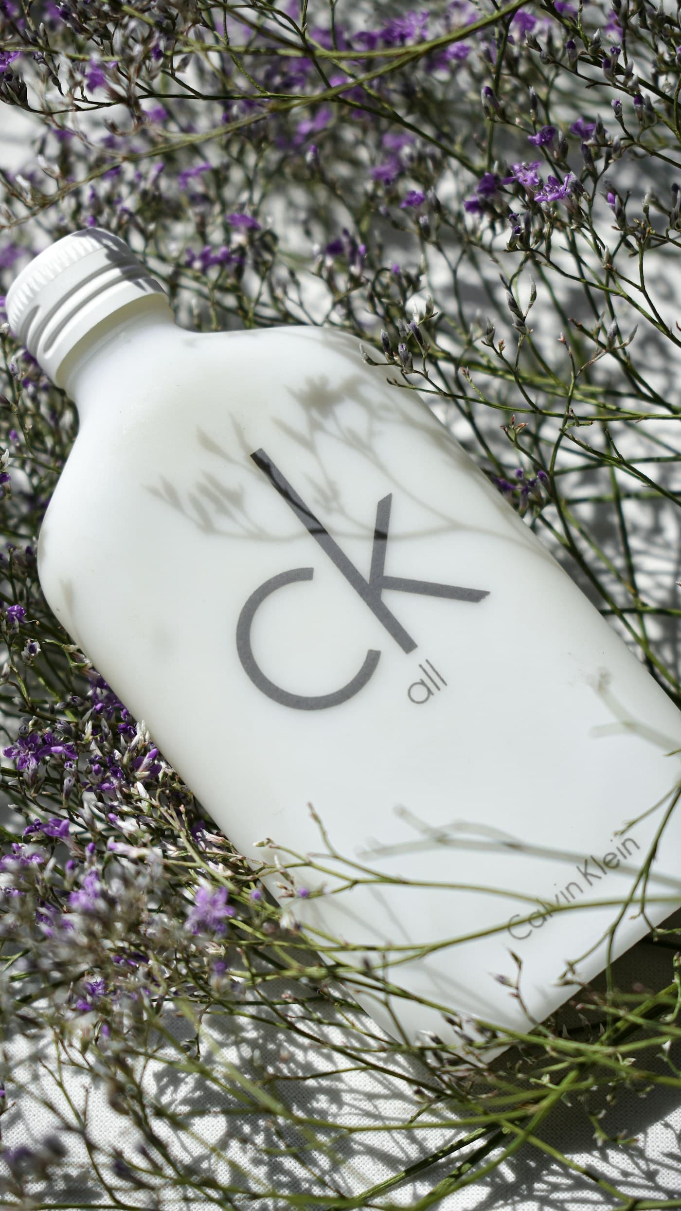 Minimal white bottle with black numbering photographed for fashion beauty.