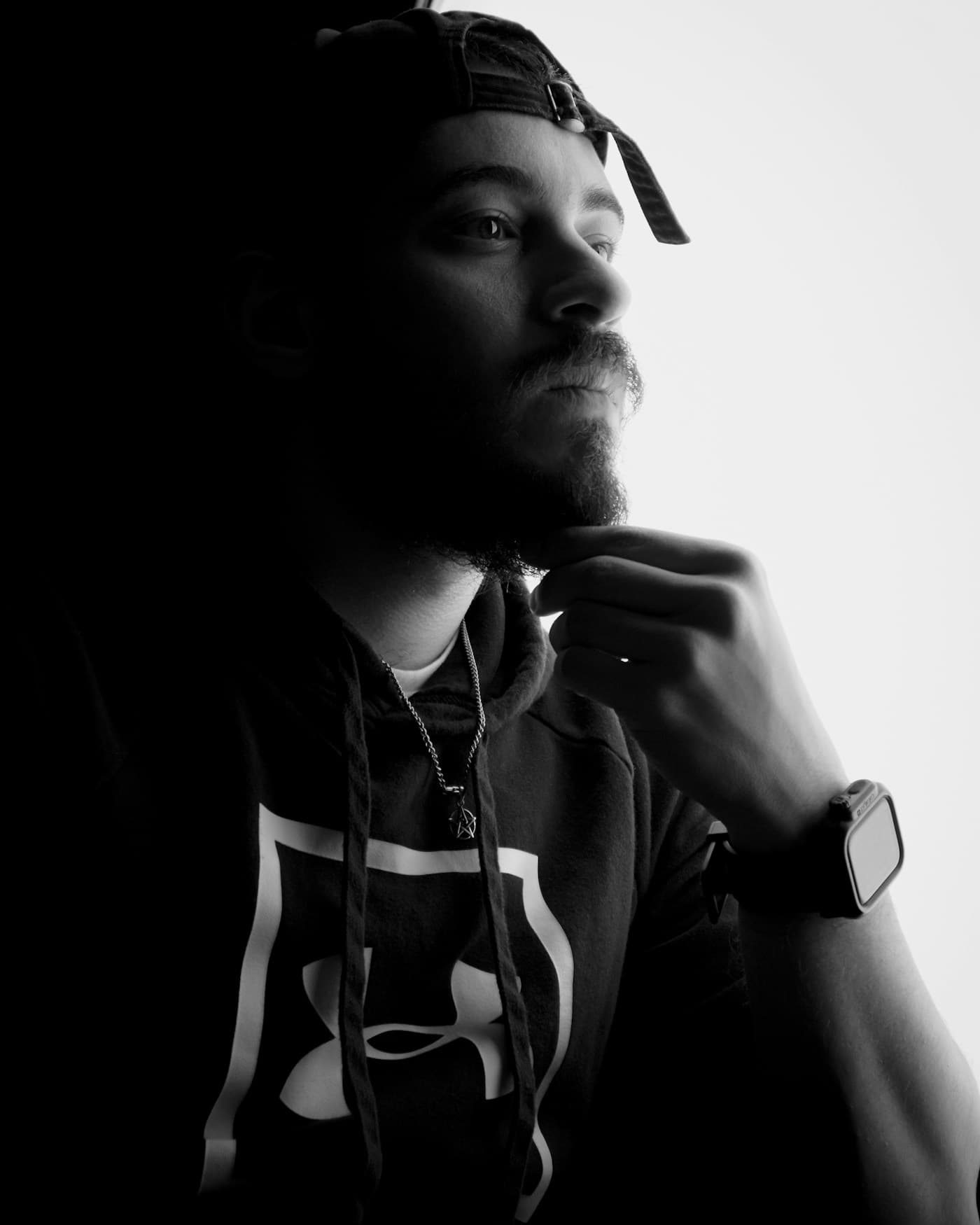 Black and white portrait of a person in sharp shadow.