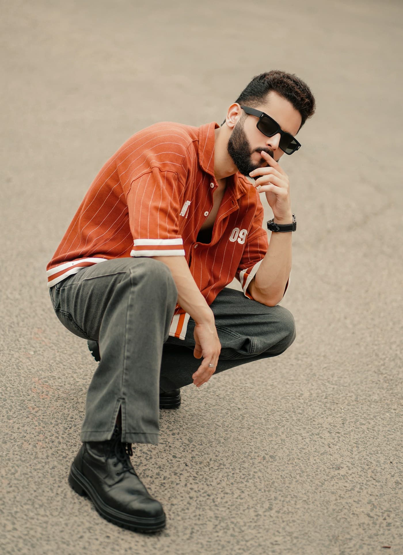 Stylish model in sunglasses and warm streetwear posing outdoors.